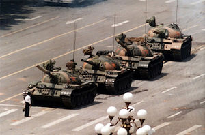 An unknown man stands before the tanks. 
