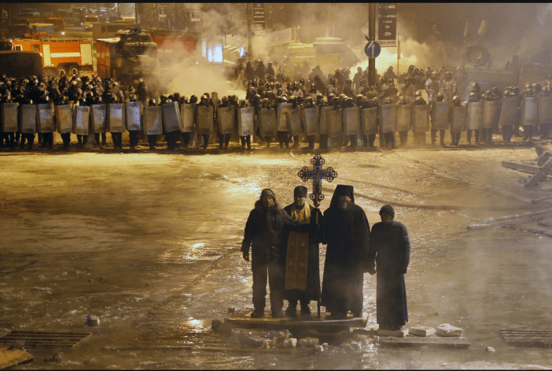 Kiev, Ukraine 01/24/2014 Orthodox priests prayed as they stood between pro-European Union activists and police lines. Sergei Grits/AP